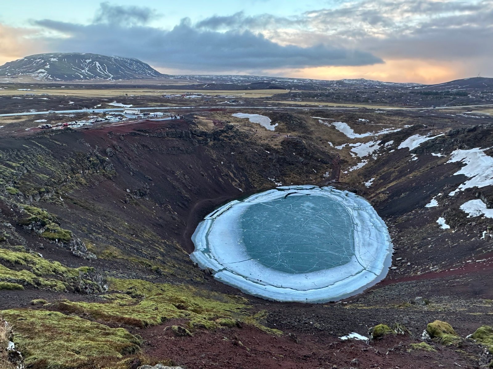 Kerið Crater Lake during the winter. You can see the contract between the red rocks, green moss and the blue froze lake.

As a cherry on top, experiencing this during sunset was even better. 

A must do!